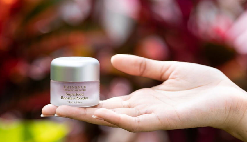 Woman's hand holding bottle of Superfood Booster-Powder